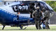 Members of a special police unit escort a man suspected to be responsible for the Solingen knife attack from a helicopter to the office of the Federal Prosecutor in Karlsruhe, southern Germany, on August 25, 2024.
