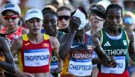 Uganda's Rebecca Cheptegei (C) applies an ice bag on her head as she competes in the women's marathon of the athletics event at the Paris 2024 Olympic Games in Paris on August 11, 2024. Photo by Kirill KUDRYAVTSEV / AFP