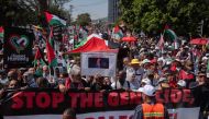 Protestors hold banners and wave Palestinian flags as they take part in a pro-Palestinian march in Cape Town, on October 05, 2024. (Photo by Rodger Bosch / AFP)