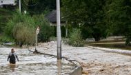 A man walks in the water along a flooded road following heavy rains in the town of Kiseljak, about twenty kilometres west of Sarajevo on October 4, 2024. Photo by Elvis BARUKCIC / AFP.