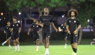 Qatar's Abdelkarim Hassan (centre) with Akram Afif (right) during a training session yesterday.