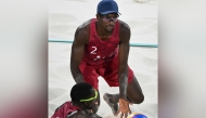 Qatar’s Cherif Younousse (down) and Ahmed Tijan in action, in this file photo.