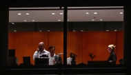 German Chancellor Olaf Scholz (L) is seen through the window speaking on the phone at the Chancellery with German Chief of Staff Wolfgang Schmidt (2nd L) in Berlin before a coalition committe meeting on November 6, 2024. (Photo by John MACDOUGALL / AFP)
