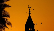 Representational image. Birds fly around the minaret of the Ali bin Ali mosque at the start of the Eid al-Fitr. Photo by KARIM JAAFAR / AFP