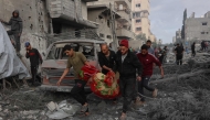 Palestinians carry the body of a victim after it was dug out from the rubble of a destroyed school, a day after it was hit by an Israeli strike, in the al-Tuffah neighbourhood of Gaza City on April 4, 2025. Photo by Omar Al-Qattaa / AFP