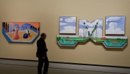 A visitor looks at paintings by British painter David Hockney ahead of the opening of the exhibition entitled 