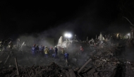 Ukrainian rescuers operate at the site of a Russian missile attack in Kyiv early on April 24, 2025, amid the Russian invasion of Ukraine. (Photo by STRINGER / AFP)
