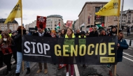 Members of Amnesty International hold a banner reading 