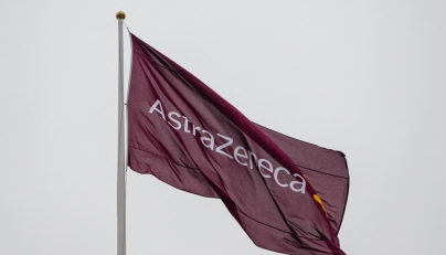 A flag with the logo of pharmaceutical company AstraZeneca flies outside their facility for biological medicines in Södertälje, south of Stockholm, Sweden on February 8, 2022. Photo by Jonathan NACKSTRAND / AFP.

