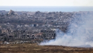 This picture taken from Israel's southern border with the Gaza Strip shows buring fields in front of destroyed houses in northern Gaza on May 4, 2025. Photo by Menahem KAHANA / AFP.