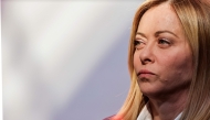 Italy's Prime Minister Giorgia Meloni looks on before posing for a family picture as part of a summit for 