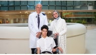 Dr. Ian Pople, Chief of Neurosurgery at Sidra Medicine with Adam and his mother.