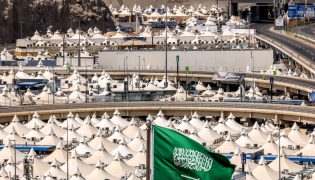 Representational file photo showing the Saudi flag as behind are pictured tents housing Muslim pilgrims in Mina near Islam's holy city of Mecca ahead of the annual Hajj pilgrimage on June 1, 2025. (Photo by Hazem Bader / AFP)