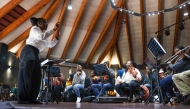 (Files) South African conductor Ofentse Pitse (L) waves her conducting baton during rehearsals at Marks Park Sports Club in Johannesburg on June 4, 2024. (Photo by Phill Magakoe / AFP)