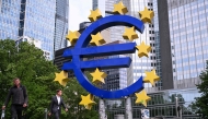 Pedestrians walk past the 'Euro Sculpture' by German artist Ottmar Hِrl in front of the former seat of the European Central Bank (ECB) at the Eurotower, ahead a press conference on the Eurozone's monetary policy, in Frankfurt am Main, western Germany, on June 5, 2025. (Photo by Kirill Kudryavtsev / AFP)
