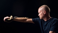 This undated handout photograph obtained from Centivax on May 30, 2025, shows US' Tim Friede posing with a water cobra. (Photo by CENTIVAX / AFP)