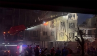This handout photo released by Iran's Revolutionary Guard Corps (IRGC) official Sepah News Telegram channel on June 13, 2025 shows onlookers and rescue teams in front of a building that caught fire following and Israeli strike on the Iranian capital Tehran early in the morning. (Photo by SEPAH NEWS / AFP)