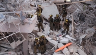 Responders work amid building rubble following a strike by an Iranian missile in the Israeli city of Bat Yam, early on June 15, 2025. (Photo by Jack Guez / AFP)