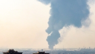 A plume of heavy smoke rises over an oil refinery in southern of Tehran, after it was hit in an overnight Israeli strike, on June 15, 2025. Photo by Atta KENARE / AFP.
