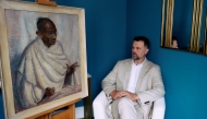 Caspar Leighton, great-nephew of British-American artist Clare Leighton, poses with an oil painting by his great-aunt, of Indian independence leader Mahatma Gandhi, at Bonhams auction house in London on June 9, 2025. Photo by BENJAMIN CREMEL / AFP