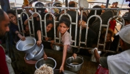 Palestinians queue to receive a hot meal at a charity kitchen in the Mawasi area of Khan Yunis in the southern Gaza Strip on July 22, 2025. (Photo by AFP)
