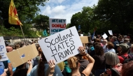 Demonstrators hold placards during a 'Stop Trump Coalition' protest near the US Consulate building in Edinburgh, Scotland on July 26, 2025. (Photo by SCOTT HEPPELL / AFP)
