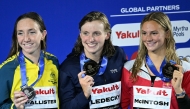 (L-R) Silver medallist Australia's swimmer Lani Pallister, gold medallist US' swimmer Katie Ledecky and silver medallist Canada's swimmer Summer McIntosh pose on the podium of the women's 800m freestyle swimming event during the 2025 World Aquatics Championships in Singapore on August 2, 2025. (Photo by Oli SCARFF / AFP)
