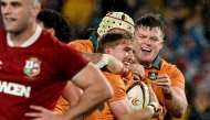 Australia's Tate McDermott (C) celebrates a try with teammates during the third rugby Test match between Australia and the British and Irish Lions at Stadium Australia in Sydney on August 2, 2025. (Photo by Saeed KHAN / AFP)
