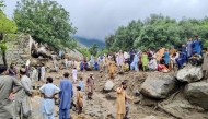 People gathered at the site of a flashflood in Salarzai Tehsil of Pakistan's Bajaur district on August 15, 2025. (Photo by AFP)