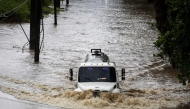 A truck drives through a flooded road as category 3 Hurricane Erin leaves the region in Naguabo, Puerto Rico on August 16, 2025. (Photo by Ricardo Arduengo / AFP)
