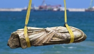 A crane pulls an artifact from the waters at Abu Qir bay in Alexandria on August 21, 2025, as part of an event organized by the Ministry of Tourism and Antiquities to recover sunken antiquities. (Photo by Khaled DESOUKI / AFP)