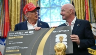 FIFA president Gianni Infantino presents US President Donald Trump a FIFA World Cup ticket for the final match in the Oval Office of the White House in Washington, DC, on August 22, 2025. (Photo by Andrew Caballero-Reynolds / AFP)
