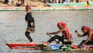 Rayyan Arkan Dikha (L), an 11-year-old boy who went viral for his calm dance on the bow of a traditional longboat, performs during the Pacu Jalur longboat race festival on the Kuantan River in Kuantan Singingi Regency, Riau Province, on August 21, 2025. Photo by Wahyudi / AFP