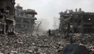 A Palestinian youth stands on a street strewn with rubble following an explosion in the Saftawi neighbourhood, west of Jabalia in the northern Gaza Strip on August 25, 2025. Photo by BASHAR TALEB / AFP