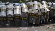Police raise their shields during a protest in front of the Regional Police headquarters in Surabaya on August 30, 2025. (Photo by Juni Kriswanto / AFP)