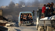 Palestinians fleeing south, ride vehicles with their belongings, on the coastal road near the Nuseirat refugee camp in the central Gaza Strip, on August 5, 2025. (Photo by Eyad Baba / AFP)