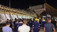 First responders and onlookers gather in front of a bridge under construction, after a section of it collapsed, killing two people and injuring others, in Karbala in southern Iraq late on September 6, 2025. Photo by Salman AMIN / AFP