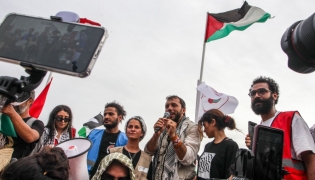 Brazilian activist Thiago Avila speaks to the crowd of pro-Palestinian activists that arrived to greet the Global Sumud Flottila at the port of the village of Sidi Bou Said on September 7, 2025. (Photo by Yassine Mahjoub / AFP)