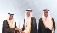 Minister of Labour, H E Dr Ali bin Samikh Al Marri, looks on as QNB official receives an award for supporting national employment during the event.