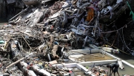 A man (R) walks on the rubble of a collapsed building after flooding in Denpasar on Indonesia's resort island of Bali on September 12, 2025. Photo by SONNY TUMBELAKA / AFP