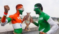Fans with their bodies painted in national flags of India (L) and Pakistan pose in Ahmedabad on September 13, 2025, with a replica of the Asia Cup 2025 trophy on the eve of the Twenty20 international cricket match between India and Pakistan in Dubai. (Photo by Sam PANTHAKY / AFP)
