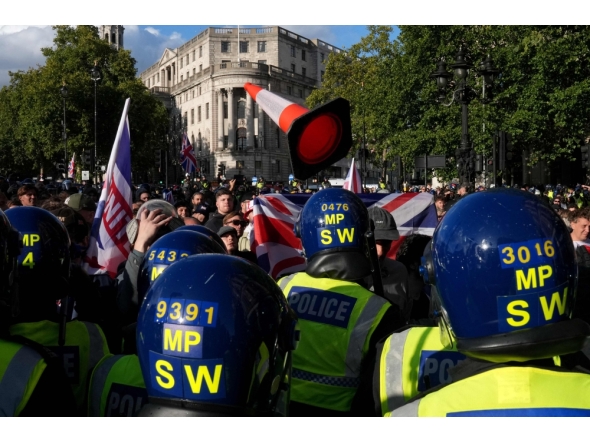 A traffic cone is thrown towards police officers as supporters of British far-right activist Tommy Robinson gather during a 'Free speech' march, in central London on September 13, 2025. (Photo by Carlos Jasso / AFP)
 