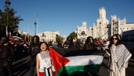 Two women hold a Palestinian flag after Pro-Palestinian protesters invaded the street during the 21st and last stage of the Vuelta a Espana 2025, a 101 km race near Cibeles fountain in Madrid on September 14, 2025.  (Photo by Oscar Del Pozo / AFP)