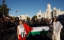 Two women hold a Palestinian flag after Pro-Palestinian protesters invaded the street during the 21st and last stage of the Vuelta a Espana 2025, a 101 km race near Cibeles fountain in Madrid on September 14, 2025.  (Photo by Oscar Del Pozo / AFP)
