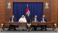 Prime Minister of Iraq H E Mohammed Shia Al-Sudani looks on as Minister of State for Energy Affairs, President and CEO of QatarEnergy, H E Saad Sherida Al-Kaabi; Chairman and CEO of TotalEnergies, Patrick Pouyanné; and other officials sign documents at a ceremony held in Baghdad yesterday.
