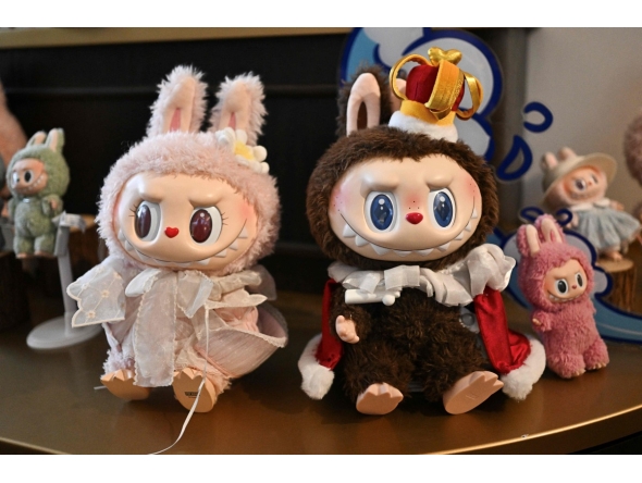 This picture taken on June 18, 2025 shows figures of the characters Mokoko and Labubu in an exhibition room at Pop Mart's theme park Pop Land in Beijing. (Photo by Pedro Pardo / AFP)

