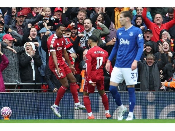 Liverpool's Dutch midfielder #38 Ryan Gravenberch (L) celebrates with Liverpool's Egyptian striker #11 Mohamed Salah (C) after scoring the opening goal of the English Premier League football match between Liverpool and Everton at Anfield in Liverpool, north west England on September 20, 2025. (Photo by Darren Staples / AFP)