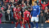 Liverpool's Dutch midfielder #38 Ryan Gravenberch (L) celebrates with Liverpool's Egyptian striker #11 Mohamed Salah (C) after scoring the opening goal of the English Premier League football match between Liverpool and Everton at Anfield in Liverpool, north west England on September 20, 2025. (Photo by Darren Staples / AFP)