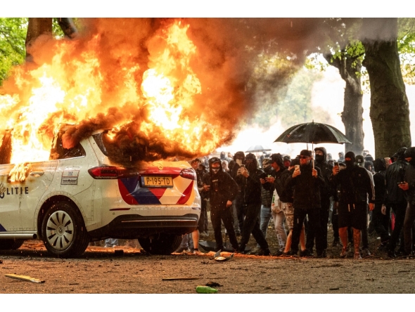 A police car is set on fire during the 