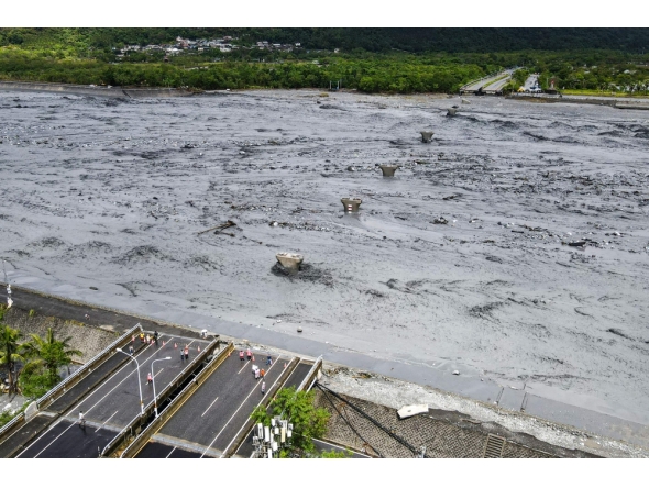 An overview shows flowing mud and floodwaters after a barrier lake burst and caused parts of the bridge over Mataian Creek be destroyed in Hualien on September 24, 2025. (Photo by Taiwan's Central News Agency (CNA) / AFP)